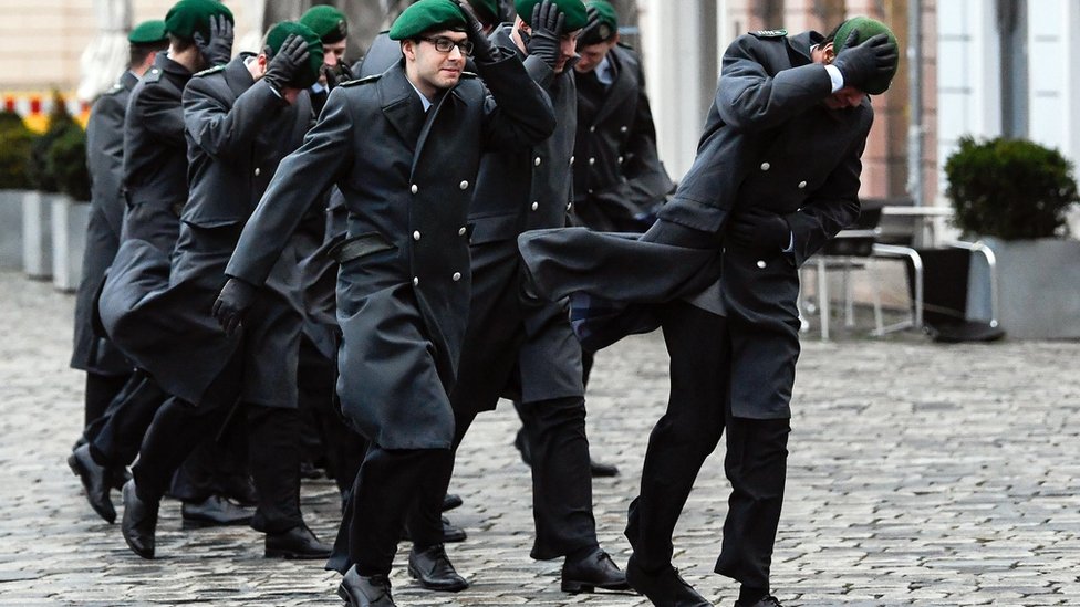 German Bundeswehr soldiers trying to keep their caps on in high winds