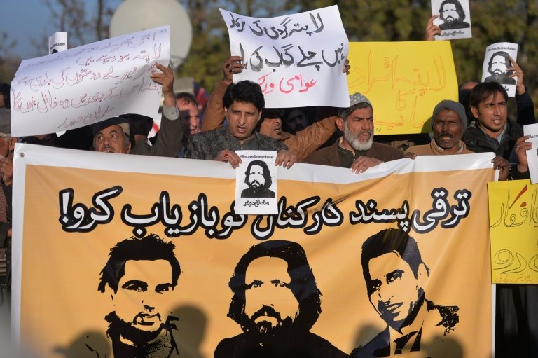 Pakistani human rights activists hold images of bloggers who have gone missing during a protest in Islamabad on January 10, 2017.