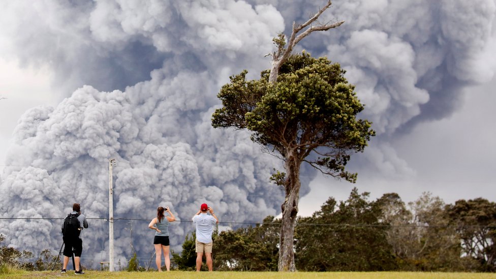 People watch as ash erupts from the Halemaumau crater near the community of Volcano during ongoing eruptions of the Kilauea Volcano in Hawaii, US on 15 May 2018.