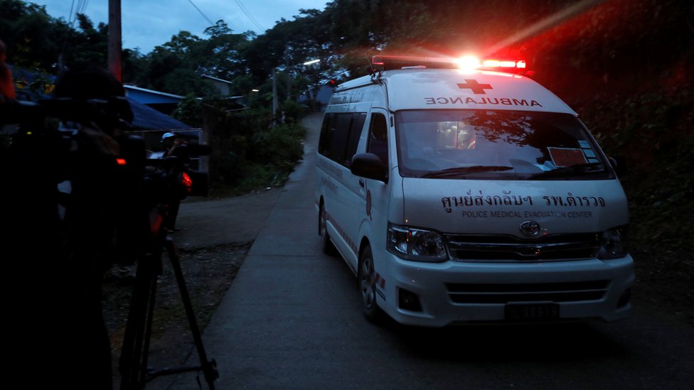 An ambulance with sirens on speeds away from the scene where children were rescued