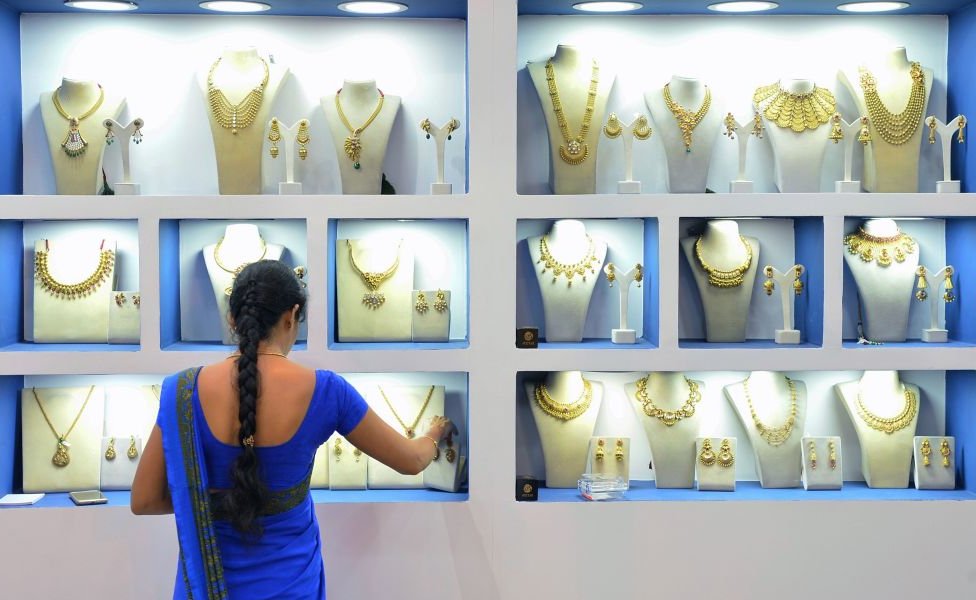 An employee of an Indian jewellery store arranges gold jewellery in Bangalore on 11 August 2017.