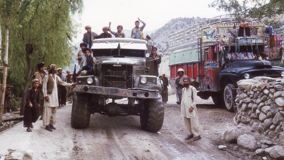 Men seen in and around a large jeep in Afghanistan