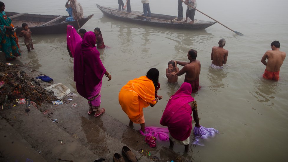 people wash themselves as they take their morning bath in the Ganges river during the Sonepur Mela on November 15, 2011