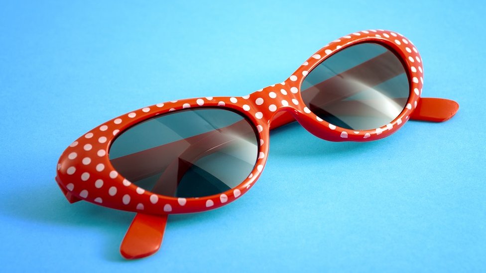 Red polka dot sunglasses, on a bright blue background