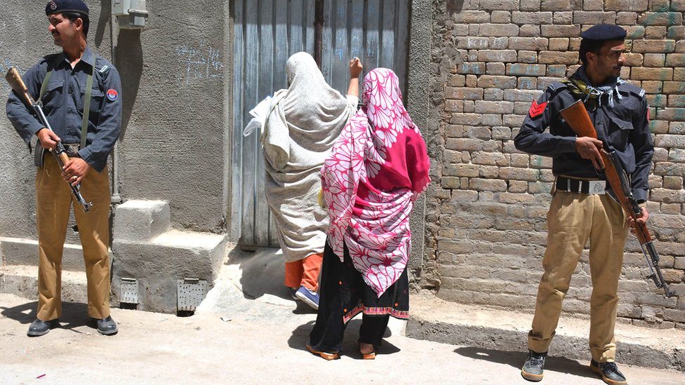 Pakistani police guard a health worker home-visit during a polio vaccination campaign in Quetta, 26 April 2016.