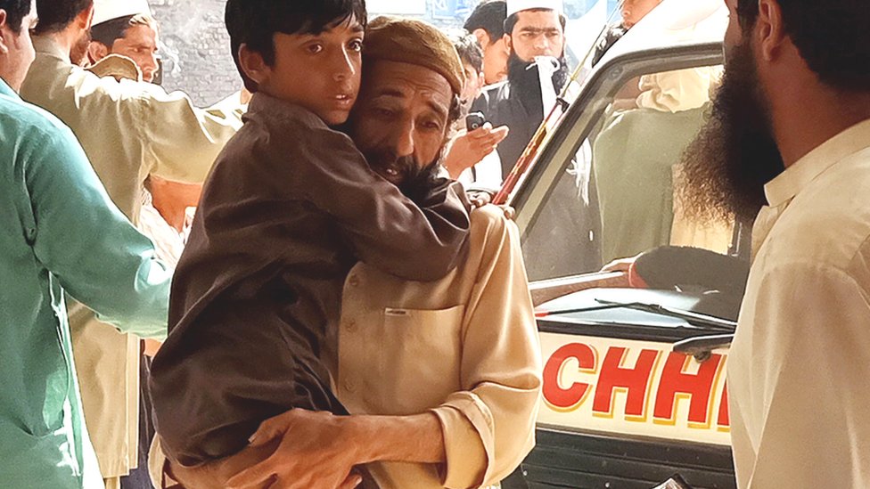 A father rushes his son to hospital after receiving a polio vaccination in Peshawar on 22 April, 2019.