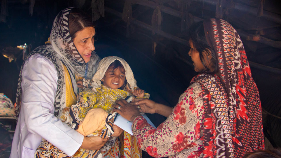 Dr Uzma Khan with a mother and child