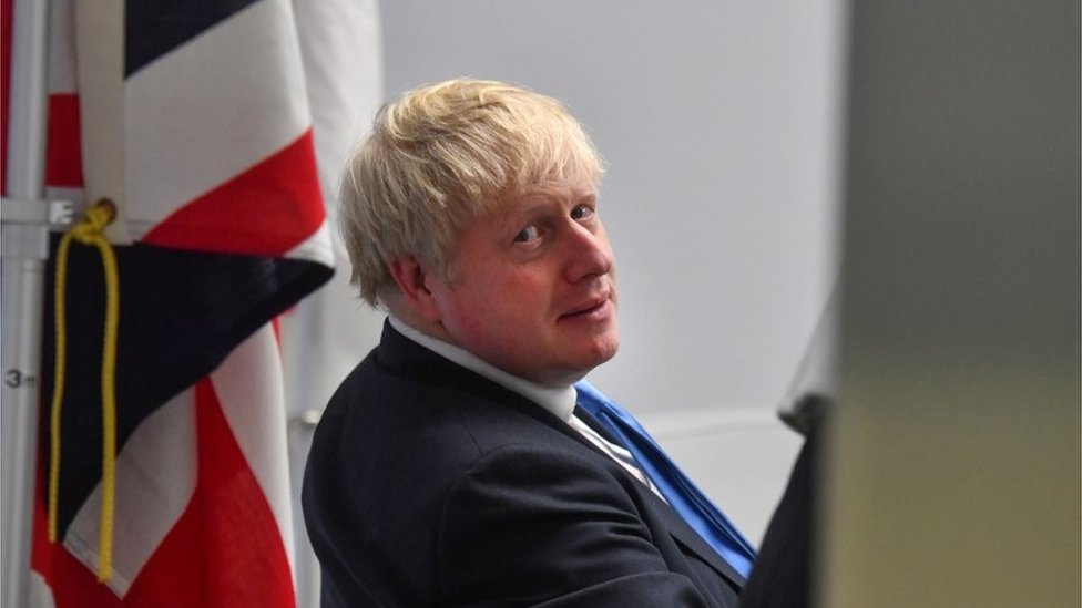 Boris Johnson next to a British flag