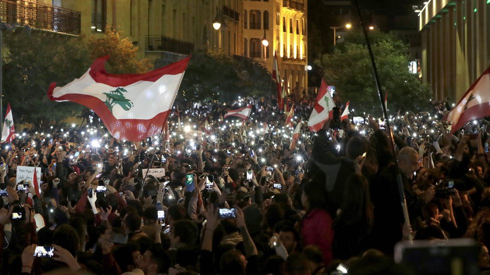 Demonstrators use their phone lights during an anti-government protest in Beirut