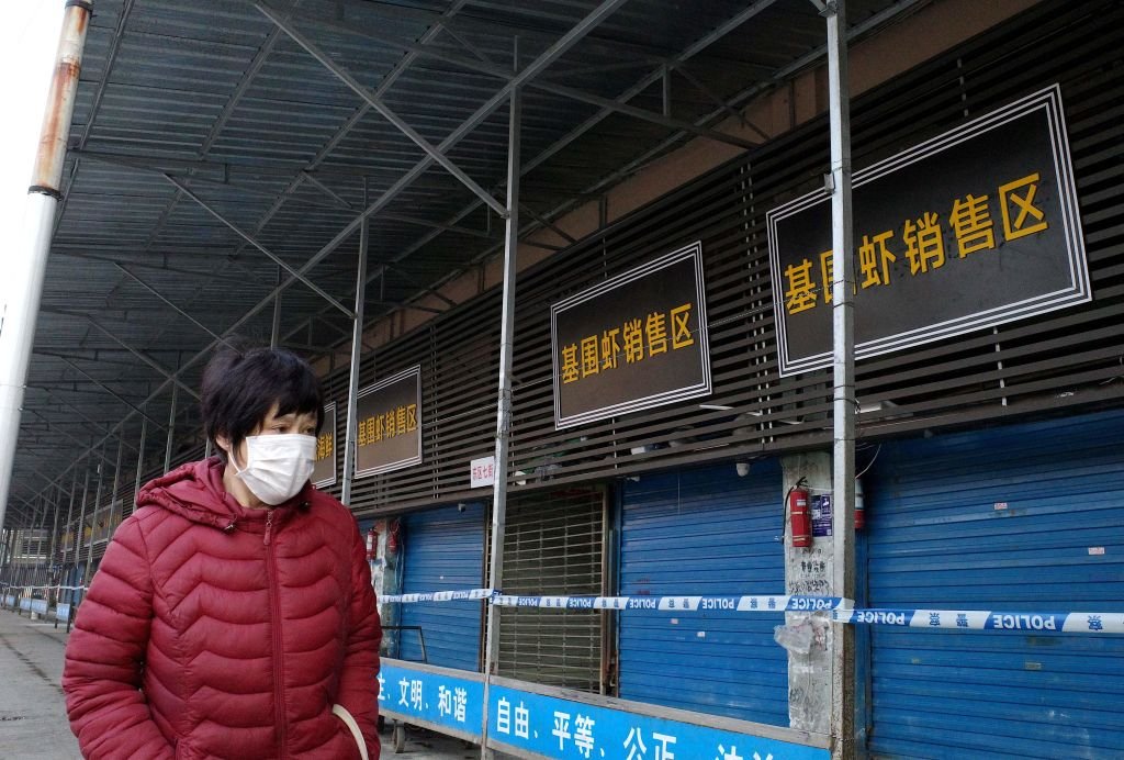 A woman walks in front of the closed Huanan wholesale seafood market in the Chinese city of Wuhan, Hubei province