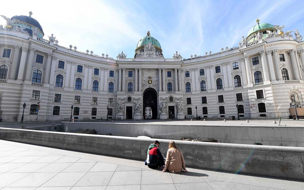 People sitting at an empty square in the centre of Vienna