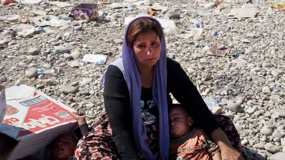 A Yazidi woman breaks down in tears after crossing from Syria back into Iraq