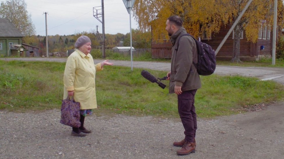 Kozlov holds a microphone towards Udgodskaya's mother-in-law