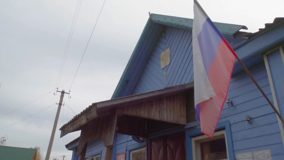 An office building with a Russian flag flying outside