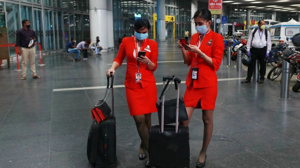 AirAsia Airlines Air hostess wearing protective mask watch on his smartphone at the Netaji Subhas Chandra Bose International Airport on June 04, 2020 in Kolkata, India.