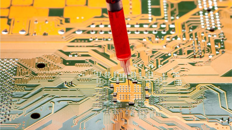 Motherboard with a syringe with needle filled with red liquid