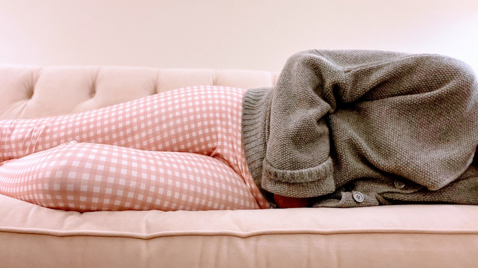 A photo of a woman lying on a sofa