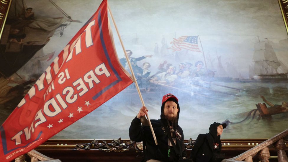 A protester carries a flag that reads 