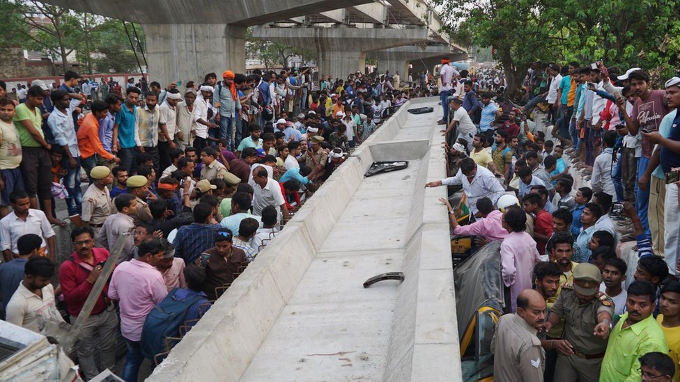 Indian bystanders gather at the site of a flyover collapse in Varanasi on May 15, 2018. At least sixteen people have been killed after a flyover collapsed on a street in Varanasi, the Press Trust of India reported.