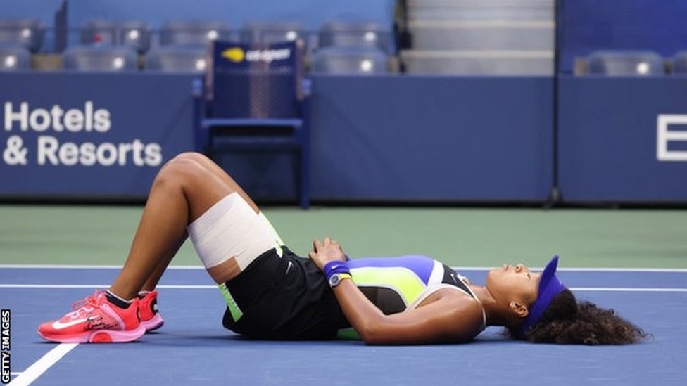 Osaka lies on the court to celebrate her win