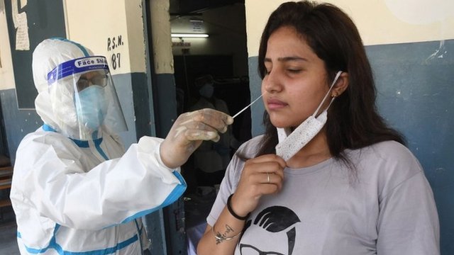 An Indian health worker takes swab samples for coronavirus and COVID-19 disease