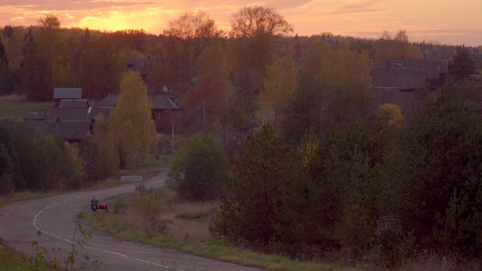 Trees surround the buildings in a small Russian village