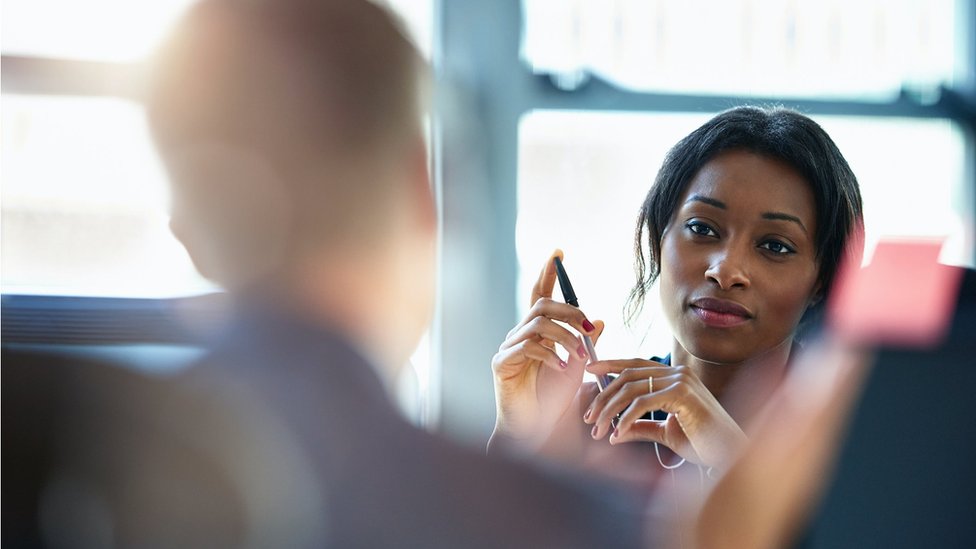 A woman and a man discuss plans in the office