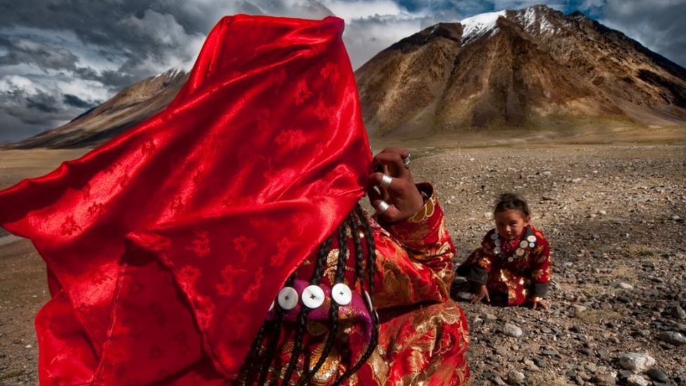 A child is looking at her mother in a mountainous region of Afghanistan