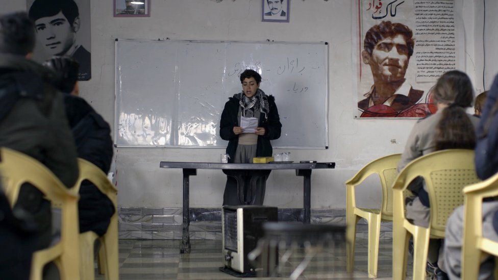 Komala member Ajin reads a poem at their base in Iraqi Kurdistan