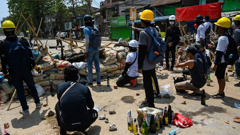 Protesters against the coup in Myanmar at barricades in Yangon's Thaketa township on Friday