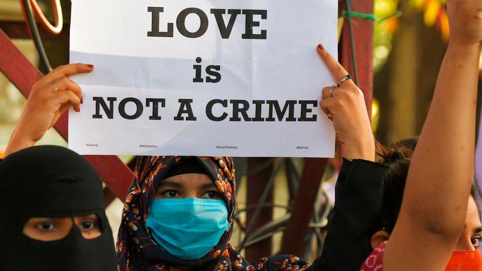 A civil right activist holds a placard during a demonstration condemning the decision of various Bharatiya Janata Party (BJP) led state governments in the country for the proposed passing of laws against 