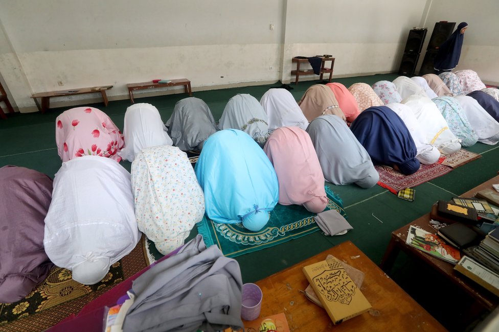 Students pray together in a row