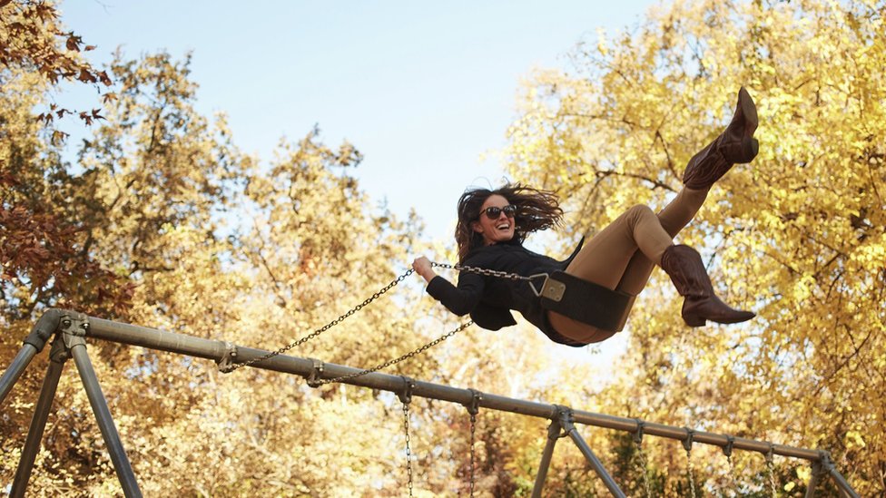 A woman on a swing in autumn