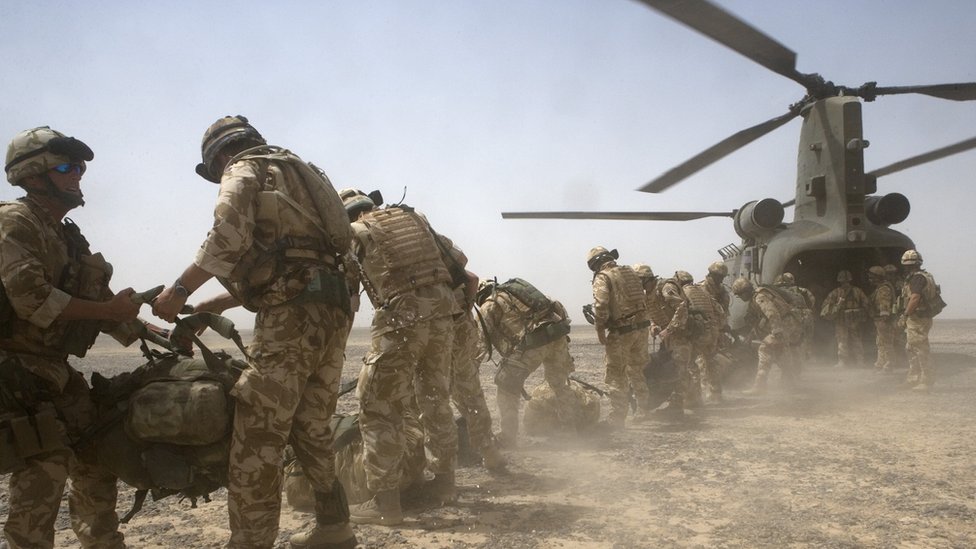 British soldiers in Afghanistan by a helicopter