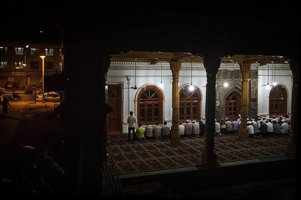 Uyghur men pray at an open air mosque in old Kashgar, Xinjiang, in 2014