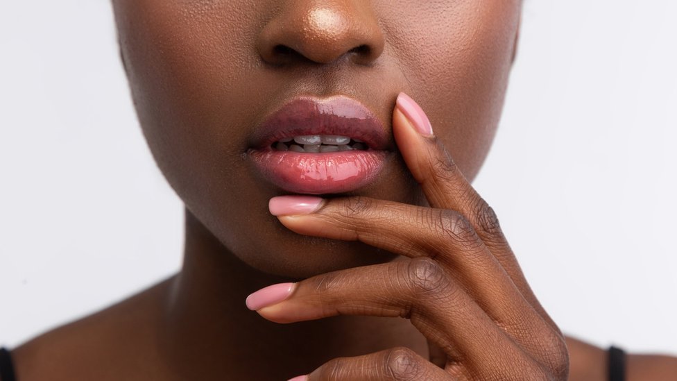 A woman holds her hand near her mouth