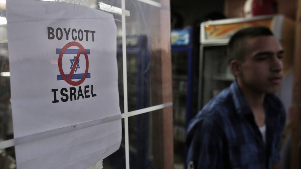 A Palestinian boy leaves a store that had erected a poster calling people to boycott Israel in east Jerusalem