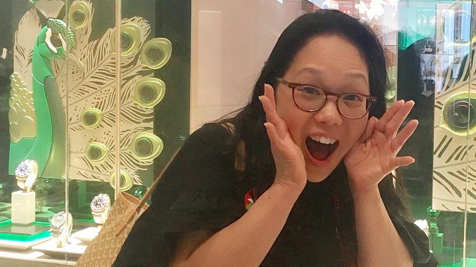 Irene Cho in front a store with peacocks in the window display