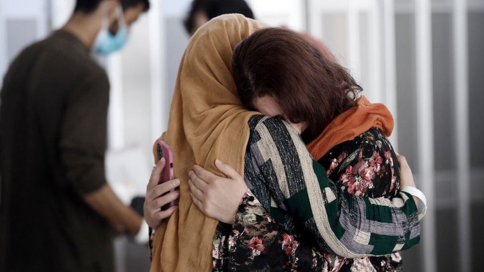 An Afghan woman greets her relative at the Vienna airport