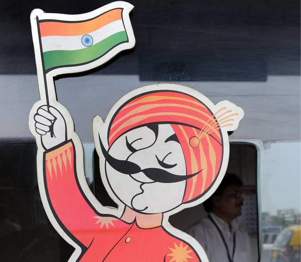 An employee is seen behind the ticket window of India's flagship carrier Air India displaying its logo the 