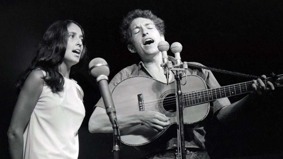 Joan Baez and Bob Dylan singing on stage
