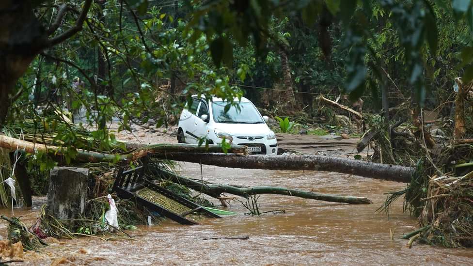 A car stuck in muddy waters after flash floods caused by heavy rains at Thodupuzha in India's Kerala state, 16 October 2021