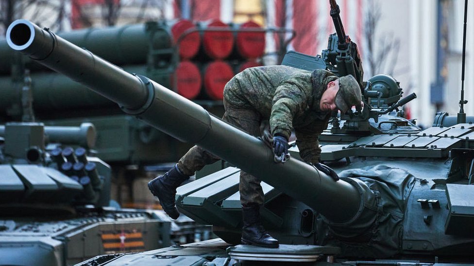 A soldier cleans military vehicles during a Victory Day Parade night rehearsal on Tverskaya street on May 4, 2022 in Moscow, Russia