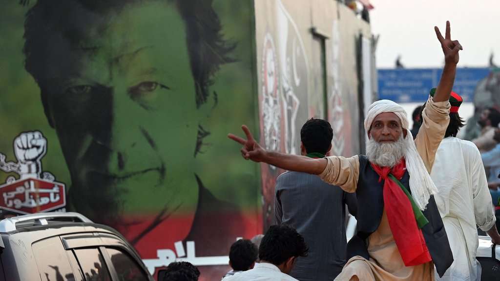A supporter of ousted Pakistan's prime minister Imran Khan flashes the victory sign as they march along a street during a demonstration in Islamabad on May 26, 2022. - Pakistan called in the army on May 26 after Khan led a rally to the capital Islamabad with thousands of supporters -- in a showdown with his political rivals that saw clashes break out between protesters and police. (Photo by Aamir QURESHI / AFP) (Photo by AAMIR QURESHI/AFP via Getty Images)
