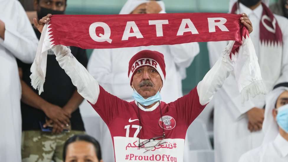 Fan holding a Qatar football scarf