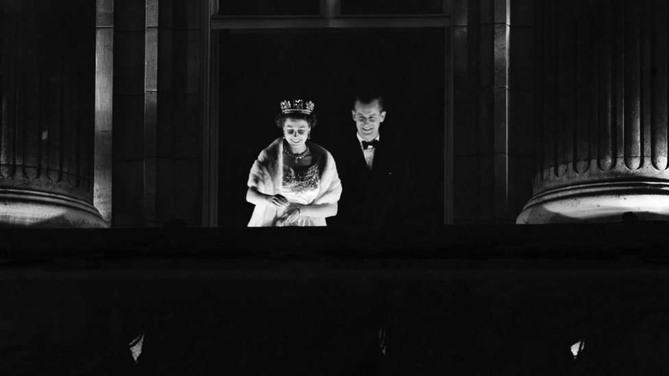 Queen Elizabeth II and the Duke of Edinburgh make their appearance on the Buckingham Palace balcony and wave to the cheering crowds around the gates.