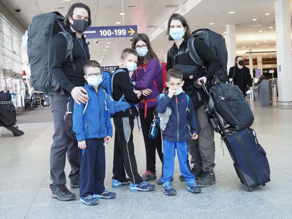 La familia posa junta para una foto en un aeropuerto.