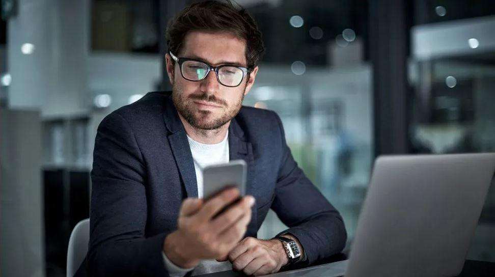 ایک شخص موبائل فون دیکھ رہا ہے