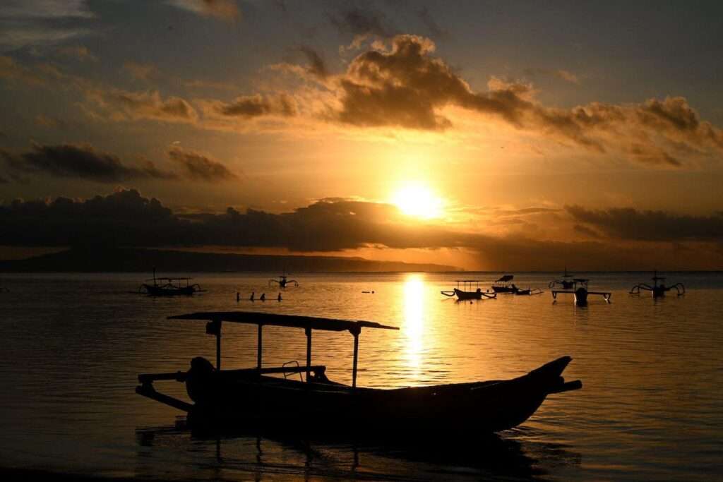 People watch the sunrise at Sanur beach on the Indonesian resort island of Bali on 6 February, 2024