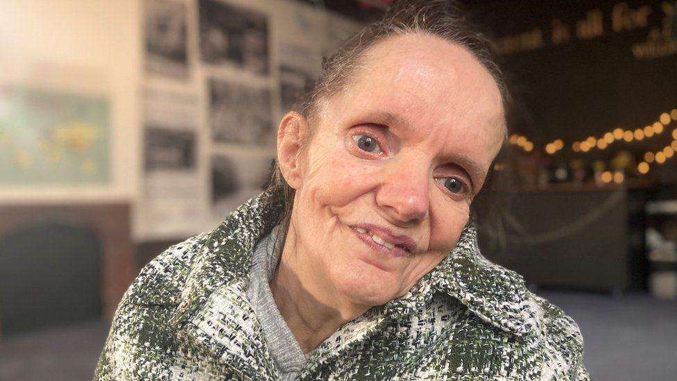 A woman looks at the camera